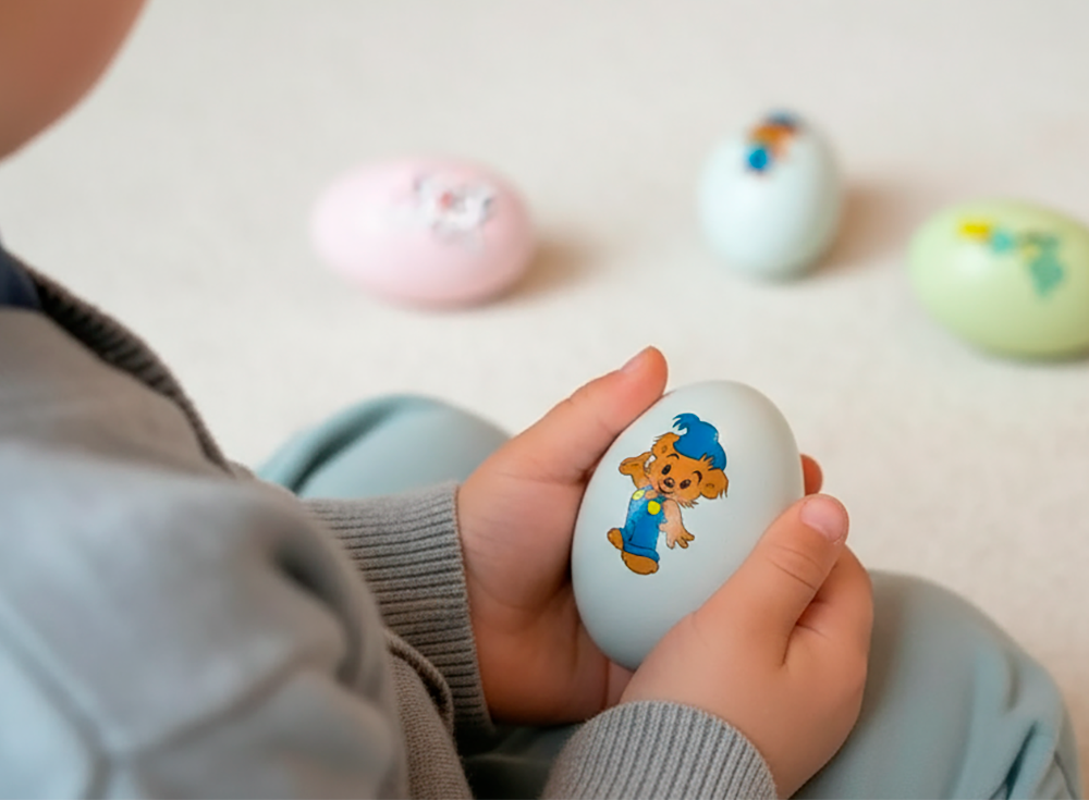 Child holding blue Bamse egg shaker